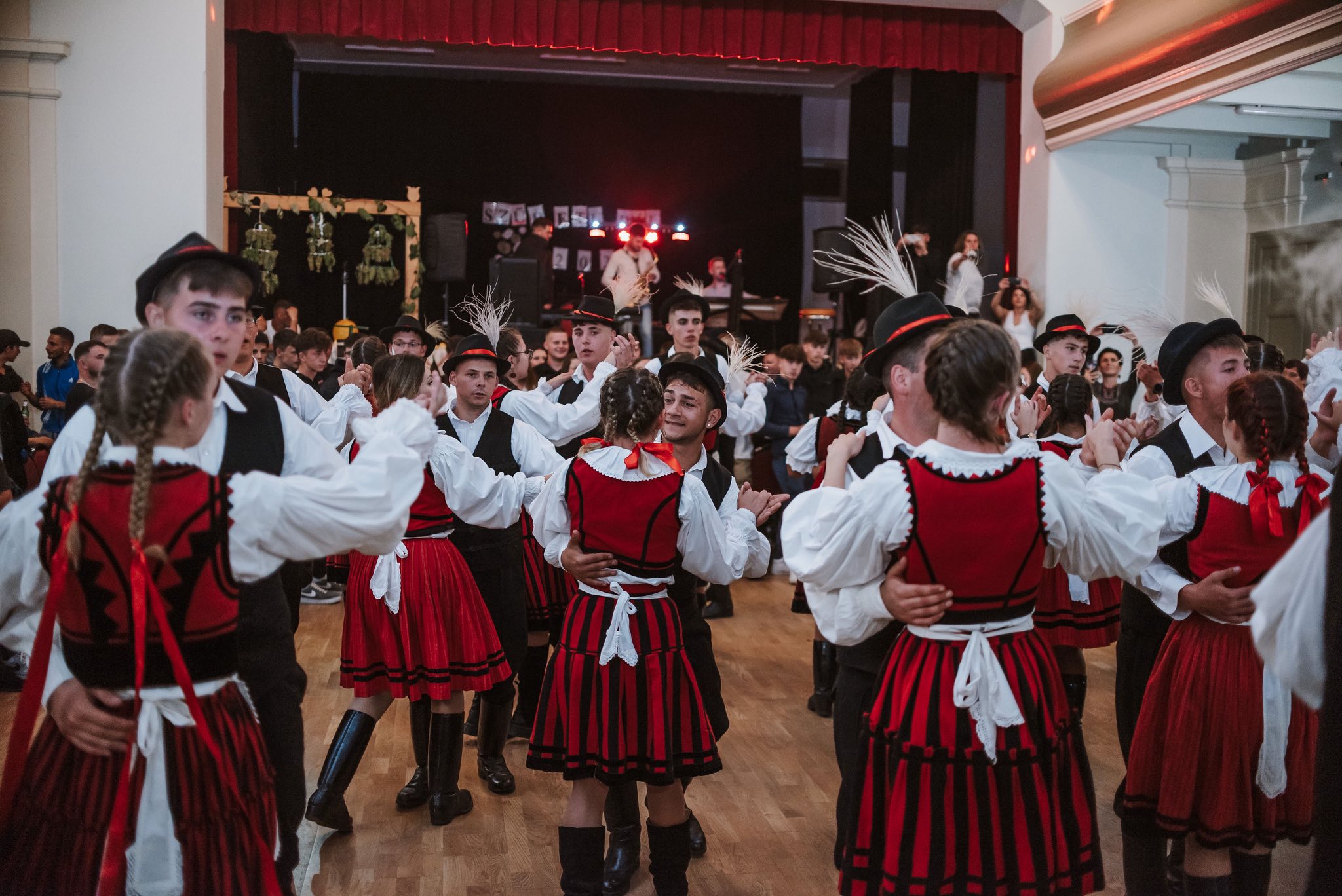 Hagyományőrző fiatalok népviseletben táncolnak a Szüreti bálon Nagyajta, Erdély